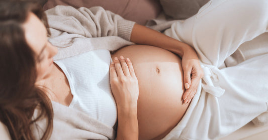 Pregnant woman touches her belly.
