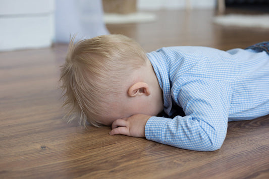 baby throws a tantrum with face pressed to the ground