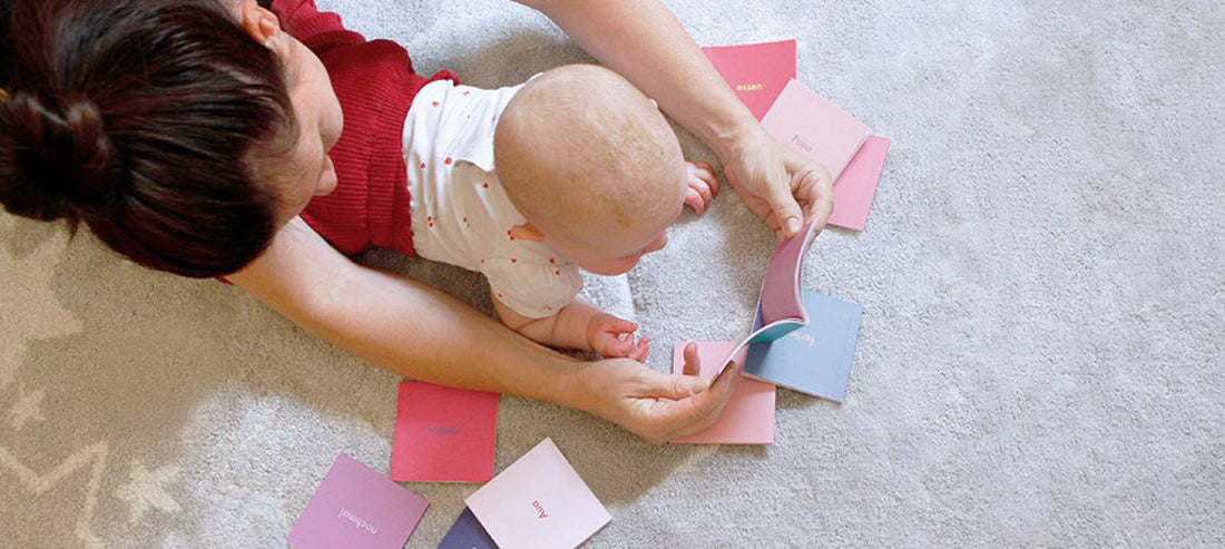 Mother and baby looking at Baby Signs cards on the floor