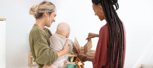 Two moms are looking at a picture book with their baby