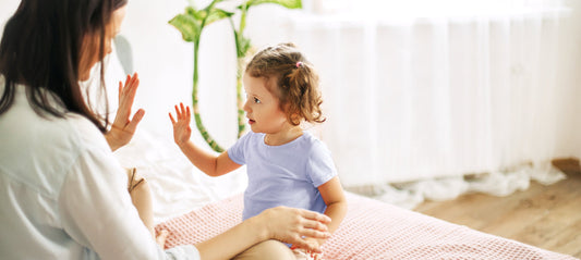 little girl learning sign language with her mom