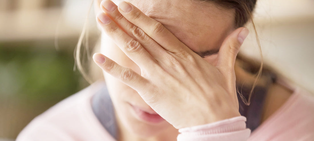 Woman desperately holds her head