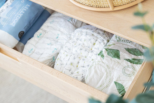 Three different diapers in an open drawer.