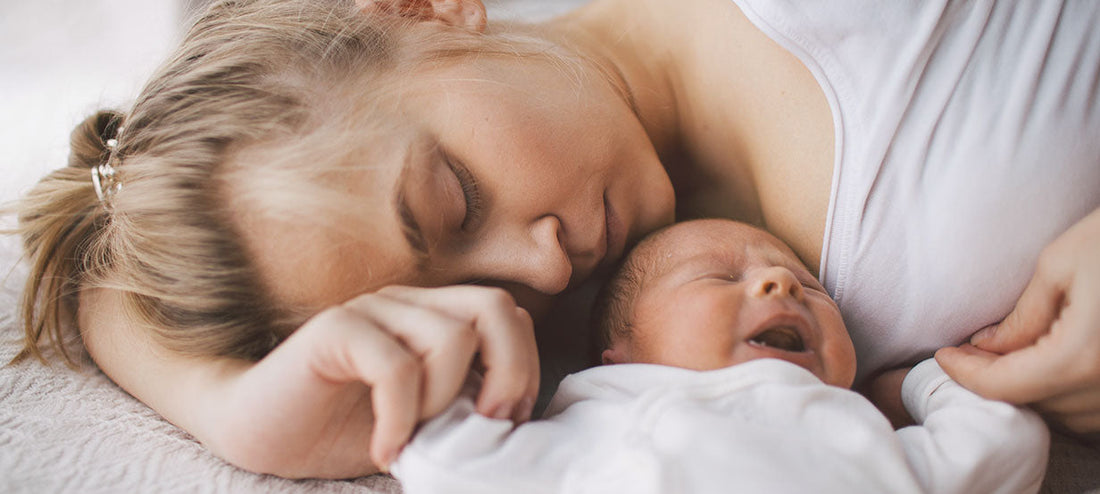 Mother is lying next to her newborn with baby blues