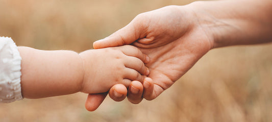 Mom and baby holding hands