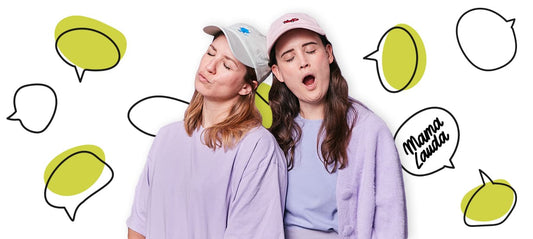 Fanny and Julia from the Mama Lauda podcast stand side by side with their eyes closed.