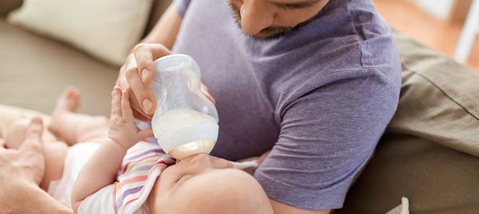 Dad giving the bottle to his baby