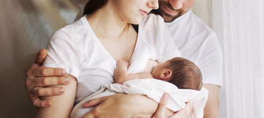 Mother and father holding their newborn in their arms
