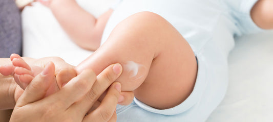 Mom applying baby cream