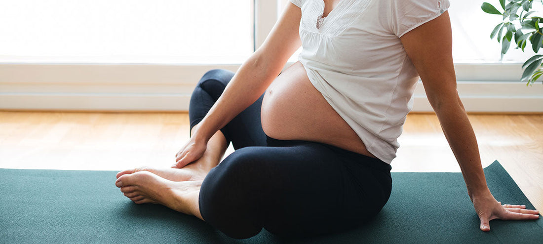 pregnant woman doing yoga on her mat