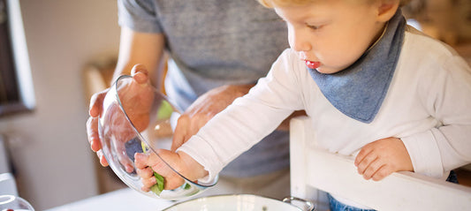 child helping his dad to cook independently