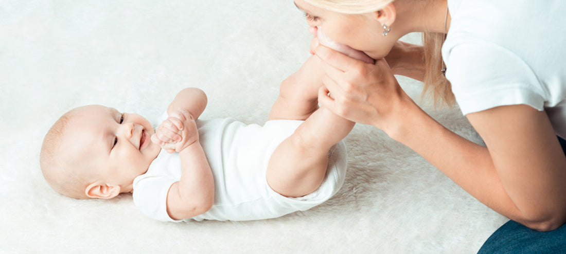 Mother tickles her baby's feet as part of the baby massage